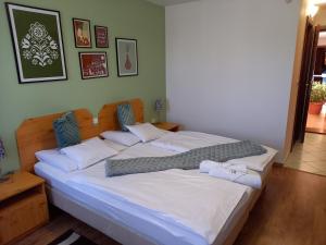A bed or beds in a room at Blum Pince - Borozó Vendégház