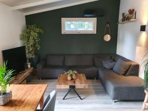 uma sala de estar com um sofá e uma mesa em Casa 2234 op camping de Schatberg em Sevenum