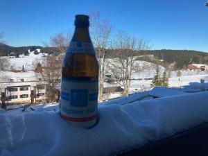 a bottle of beer sitting on top of snow at Ferienwohnung Ausblick in Missen-Wilhams