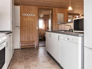 a kitchen with white cabinets and a sink at 6 person holiday home in R m in Bolilmark