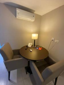 a room with a table and chairs and a telephone at Beach Class Internacional apartamento in Recife