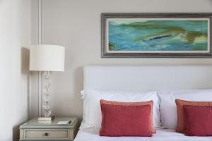 a bedroom with a bed with red pillows and a painting at Splendido, A Belmond Hotel, Portofino in Portofino