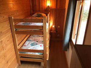 Zimmer mit Etagenbett und 2 Etagenbetten in einer Hütte in der Unterkunft Le chalet in Saint-Quentin-Lamotte-Croix-au-Bailly