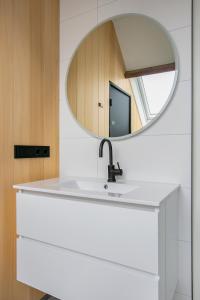 La salle de bains est pourvue d'un lavabo et d'un miroir. dans l'établissement Hello Zeeland - Appartement Weststraat 36, à Domburg