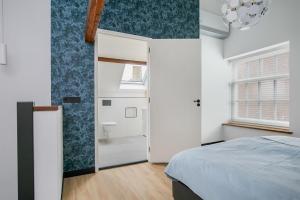a bedroom with a bed and a bathroom at Hello Zeeland - Appartement Weststraat 36 in Domburg