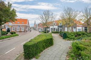 a street in a town with houses and trees at Hello Zeeland - Appartement Weststraat 36 in Domburg