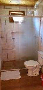 a bathroom with a toilet and a glass shower at Amanhecer na Serra in Urubici