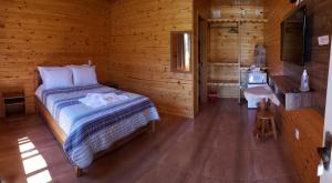 1 dormitorio con 1 cama en una cabaña de madera en Amanhecer na Serra, en Urubici