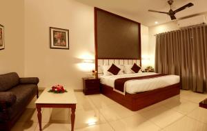 a hotel room with a bed and a couch at Bhasuri Inn Guruvayoor in Guruvāyūr
