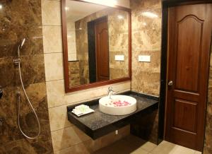 a bathroom with a sink and a shower at Bhasuri Inn Guruvayoor in Guruvāyūr +54 photos
