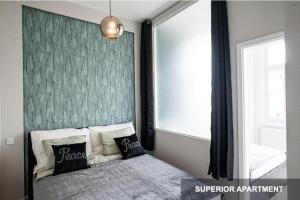 een slaapkamer met een bed met een groene muur bij BpR Agathé Elegant Suite with Parliament View in Boedapest
