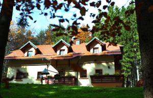 een groot wit huis met een rood dak bij Green Village Ruševec in Hočko Pohorje