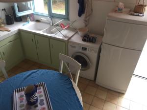 a kitchen with a sink and a washing machine at Maison 100 m plage, 2 kms du port in L'Ile d'Yeu +7 photos