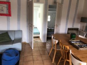 a living room with a table and a couch at Maison 100 m plage, 2 kms du port in L'Ile d'Yeu