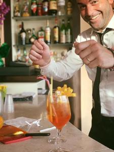 un homme debout dans un bar préparant un verre dans l'établissement Gran Paradiso Hotel Spa, à San Giovanni Rotondo