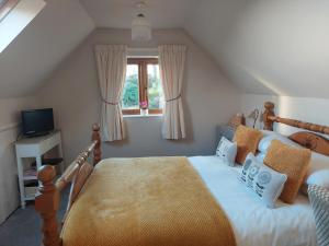 1 dormitorio con cama y ventana en Innisfree Cottage, en Eyam