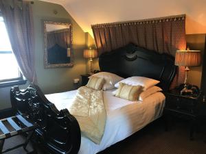 Knockninny Country House في Derrylin: غرفة نوم بسرير كبير عليها شراشف ووسائد بيضاء
