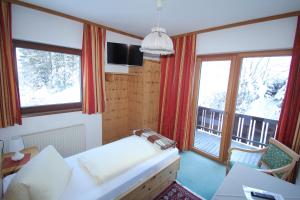 uma sala de estar com um sofá e duas janelas em Pension Hubertushof beim Römerbad em Bad Kleinkirchheim