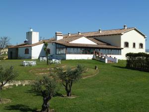 a large white building with tables and chairs in a yard at Casa Rural Las Canteras in Trujillo