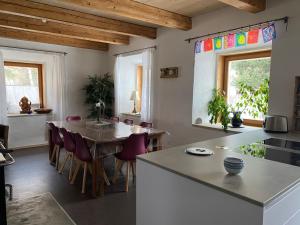 cocina y comedor con mesa y sillas en Wohnung mit Charme im Künstlerviertel in der Villa Stailamar in Susch en Sur