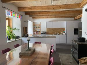 una cucina e una sala da pranzo con tavolo e sedie in legno di Wohnung mit Charme im Künstlerviertel in der Villa Stailamar in Susch a Susch