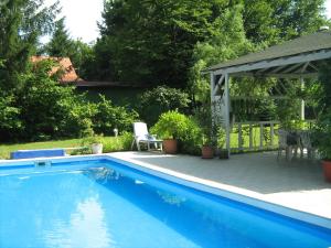 a swimming pool in a yard with a gazebo at Guest House Westwood in Kraljevec Kupinečki