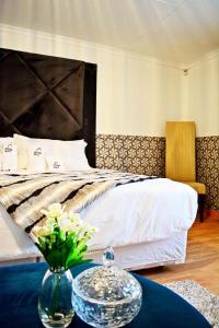 Un dormitorio con una cama y una mesa con flores. en MaU Bed and Breakfast, en Krugersdorp