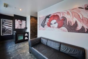 a living room with a couch and a painting on the wall at YOOMA Urban Lodge in Brussels