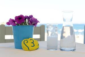 a table with a vase of flowers and a glass of water at Kordistos Hotel in Kefalos