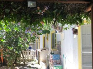 una casa con porte bianche e un albero di Espaço mel a Búzios