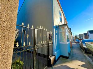 een blauw gebouw met een poort in een straat bij Mill Cottage, New Refurbished, 2 Bed, Cleethorpes in Cleethorpes