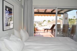 a bedroom with a white bed and a balcony at Sea View Riviera- 4 bed apartment in Riviera del Sol with beautiful sea view! in La Cala de Mijas +21 photos