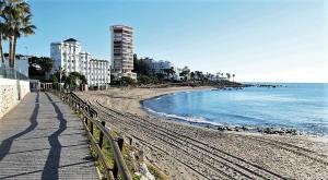 a sandy beach with buildings and the ocean at Sea View Riviera- 4 bed apartment in Riviera del Sol with beautiful sea view! in La Cala de Mijas