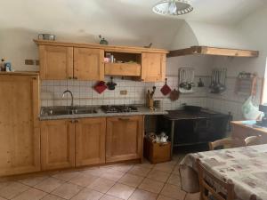 une cuisine avec des armoires en bois et un four à plaques de cuisson dans l'établissement Maso Pallabazzer - Colle Santa Lucia, à Colle Santa Lucia 27 autres photos