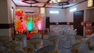 a room with a bunch of chairs and a stage at Jjs PARK INN in Chennai