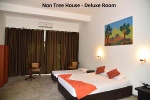 A bed or beds in a room at Wilpattu Tree House