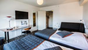 una camera d'albergo con 2 letti e una scrivania di Hotel Hans Egede a Nuuk