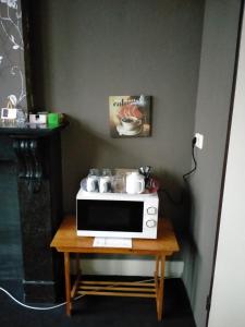 a microwave sitting on top of a wooden table at Op de Burg in Venlo