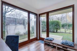 Zimmer mit großen Fenstern, einem Bett und einem Tisch in der Unterkunft Madarhegy Apartment with garden Buda side in Budapest