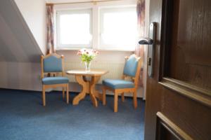 a table with two chairs and a vase of flowers on it at Corso in Kühlungsborn