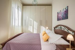 a bedroom with a bed with a purple blanket and pillows at The Lagoon Luxury House in Argostoli