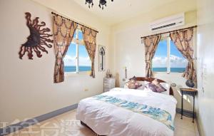 a bedroom with a bed with a view of the ocean at Yan Hai De Dai B&B in Magong