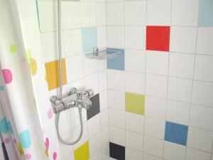 a bathroom with a shower with colorful tiles at B&B Hotel California in Wichmond