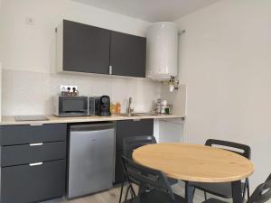 eine kleine Küche mit einem Tisch und einer Mikrowelle in der Unterkunft Studio 3 in Moirans-en-Montagne