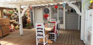 eine Veranda mit einem Tisch und Stühlen auf einer Terrasse in der Unterkunft Loft dans les Vosges idéal 2 personnes in Le Thillot