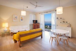 un soggiorno con divano giallo e tavolo di Residence Ai Vigneti With Pool a Bardolino