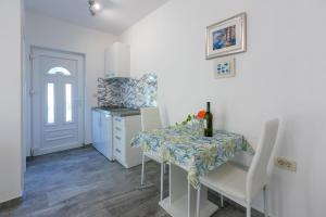 a small kitchen with a table and chairs and a counter at Apartment Nada in Mundanije