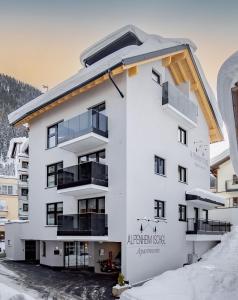 um edifício de apartamentos branco na neve em Alpenheim Apartment Ischgl em Ischgl