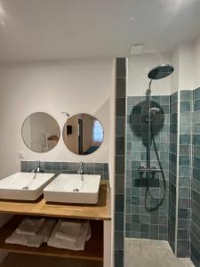 uma casa de banho com 2 lavatórios e um chuveiro em La maison Barberousse em Gruissan