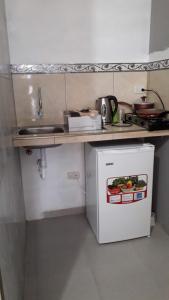 a small kitchen with a sink and a white refrigerator at Habitacion Vacacional Camboriu in Salinas